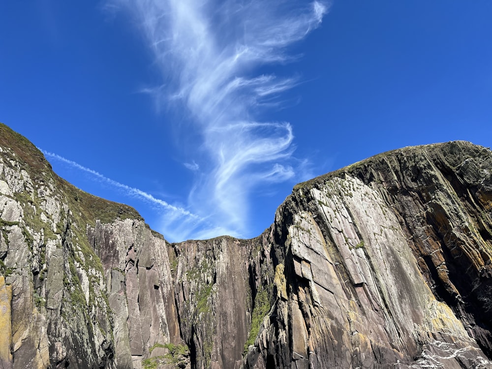 a rocky cliff with a blue sky