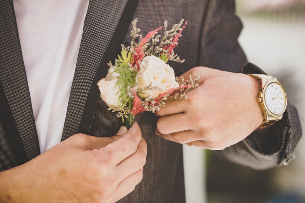 a person in a suit holding a bouquet of flowers