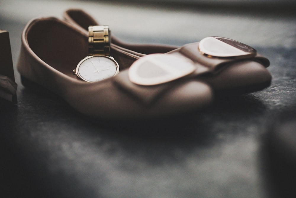 a brown leather shoe with a gold ring on it