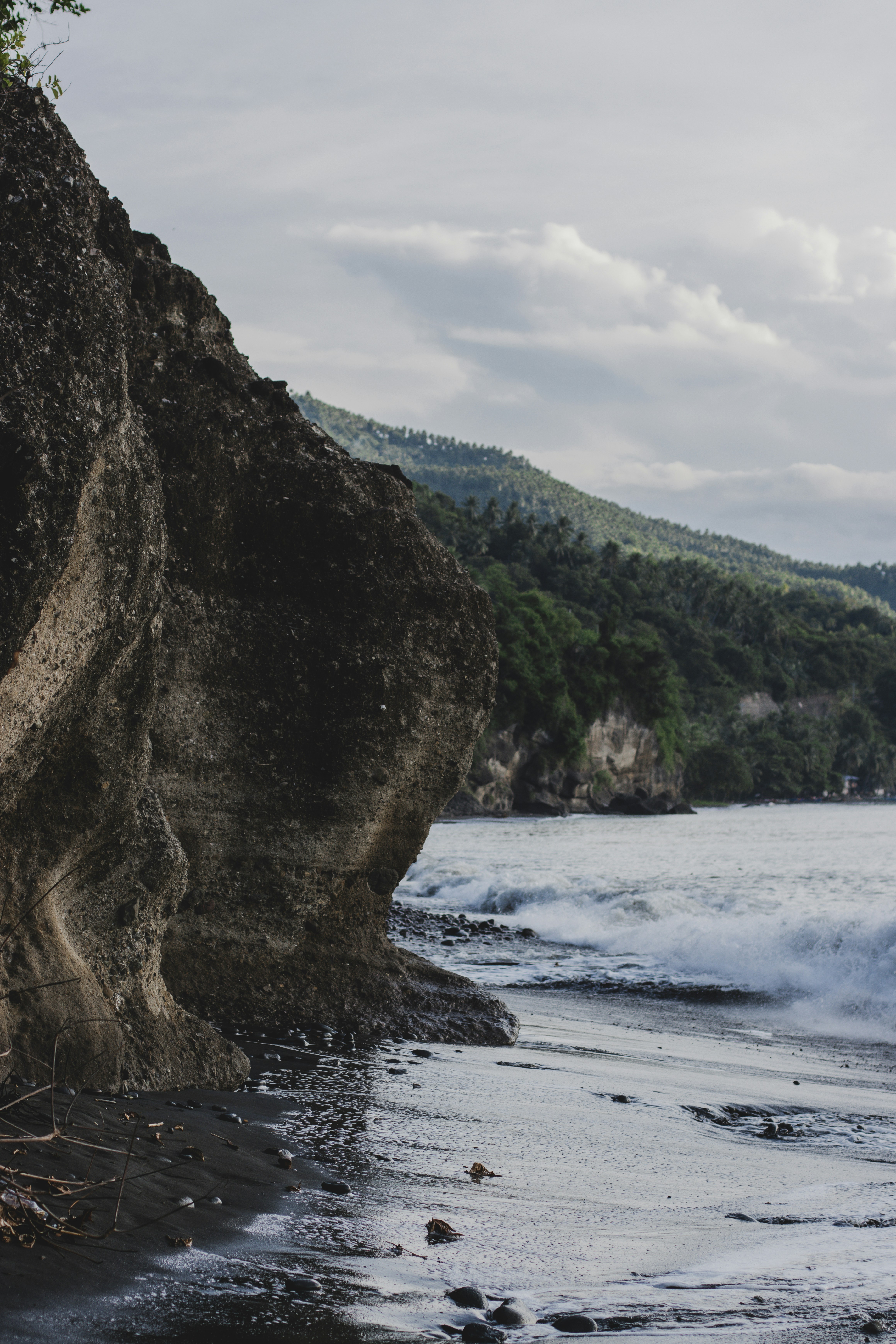 a rocky cliff next to a body of water