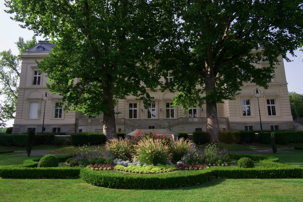 a large building with a lawn and trees in front of it