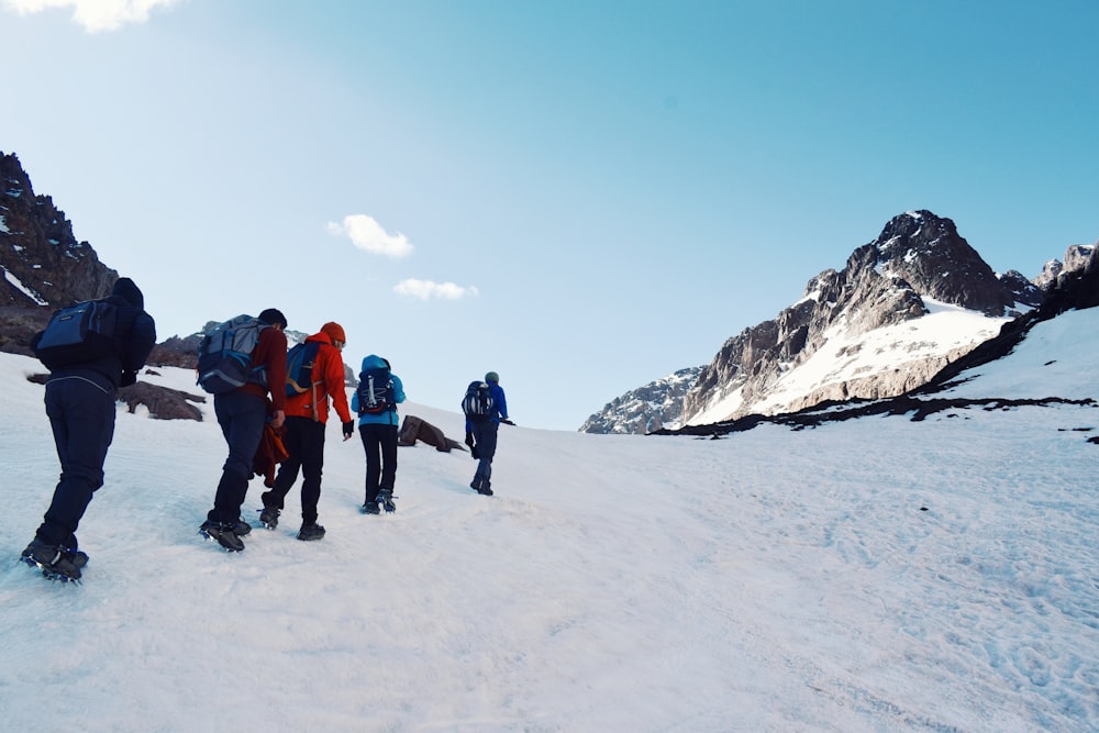 a group of people standing on a snowy mountain