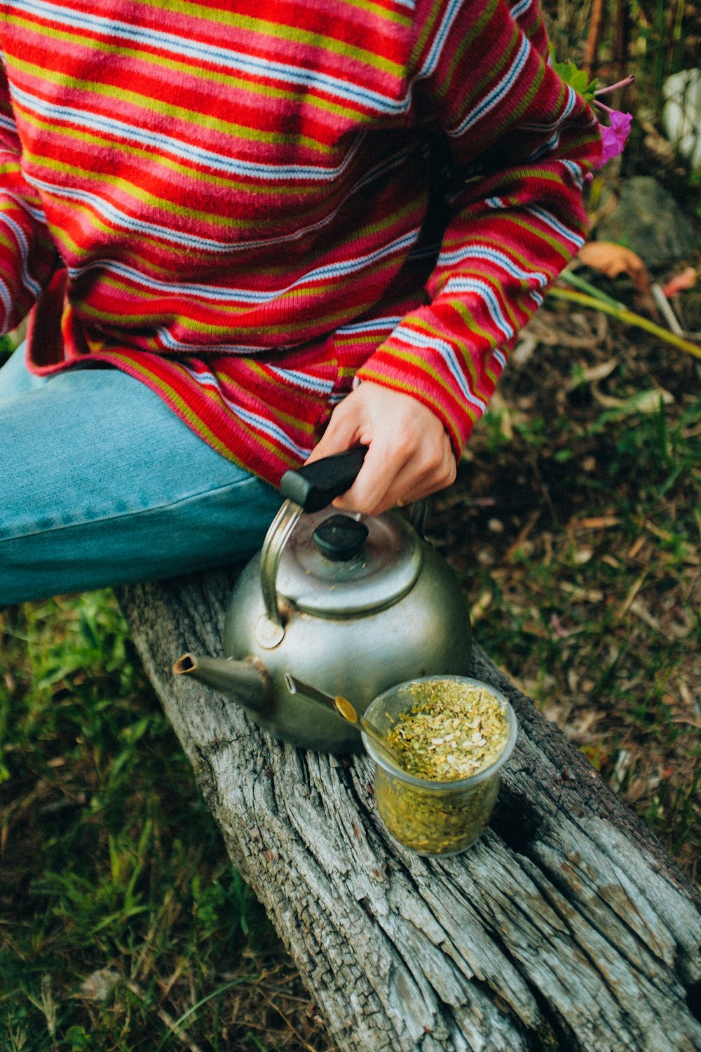 a person holding a metal object with a liquid in it