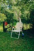Foldable outdoor recliner placed beside a garden with blooming flowers.
