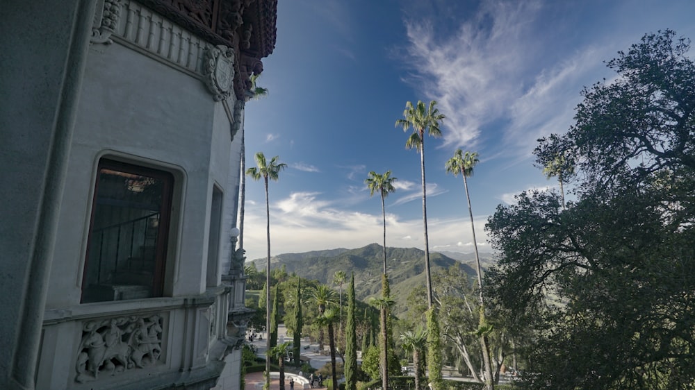 um edifício com árvores e montanhas ao fundo