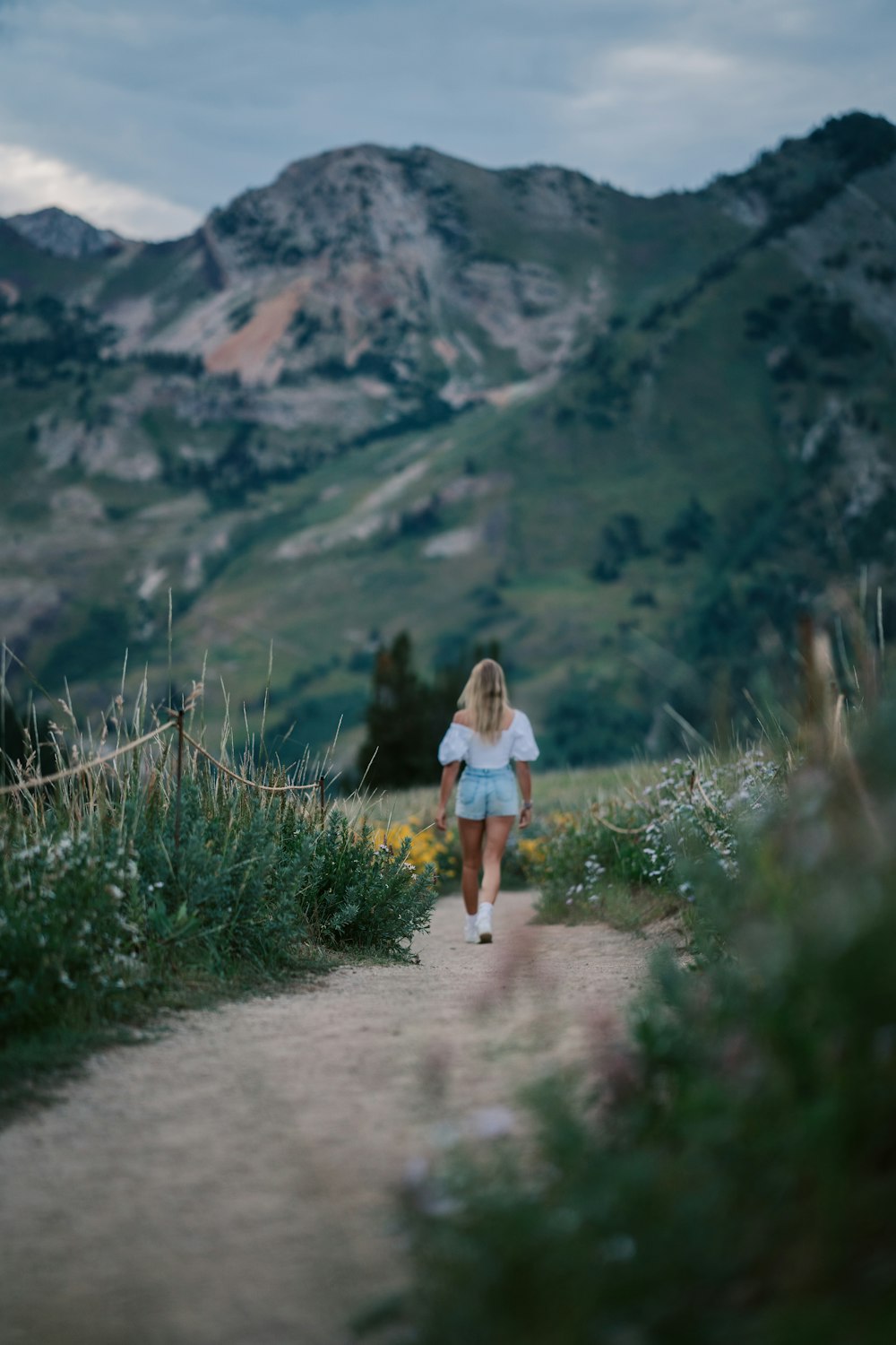 a person walking on a trail in a hilly area