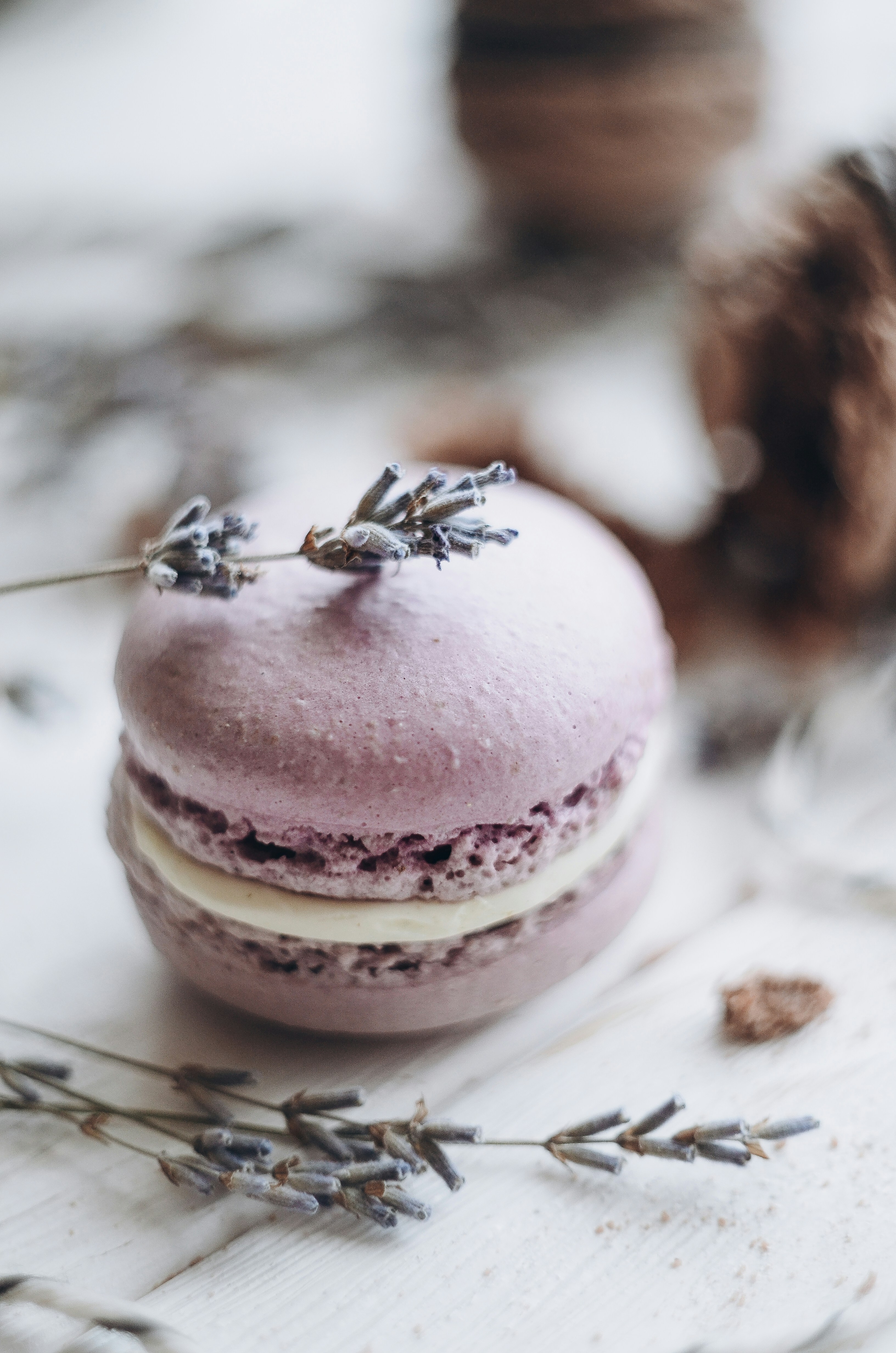 Pastel macaron tower with lavender and rose flavors on silver stand against blush background