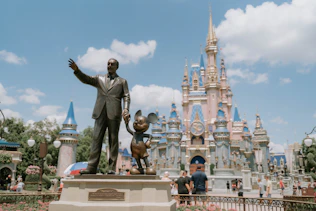 a statue of a man in front of a castle