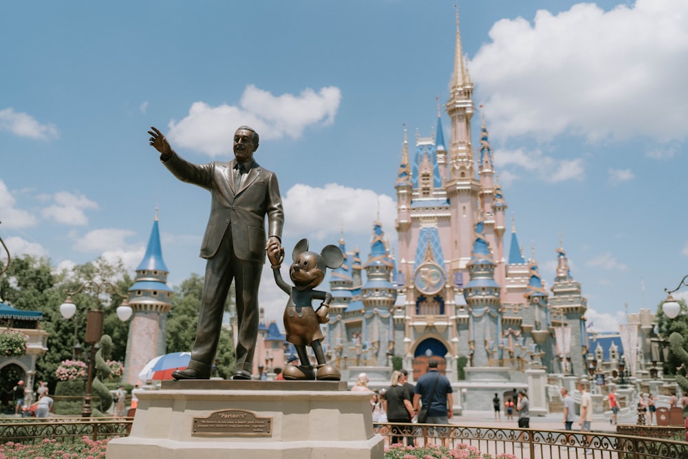 a statue of a man in front of a castle