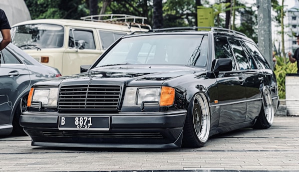 A luxury sedan and a spacious van parked side by side in a serene suburban street.