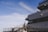 A large cruise ship is docked, featuring a person in uniform standing on the deck near the railing under a clear blue sky. The ship is named 'Odyssey' with its name visible on the side. The scene conveys an atmosphere of anticipation or readiness.