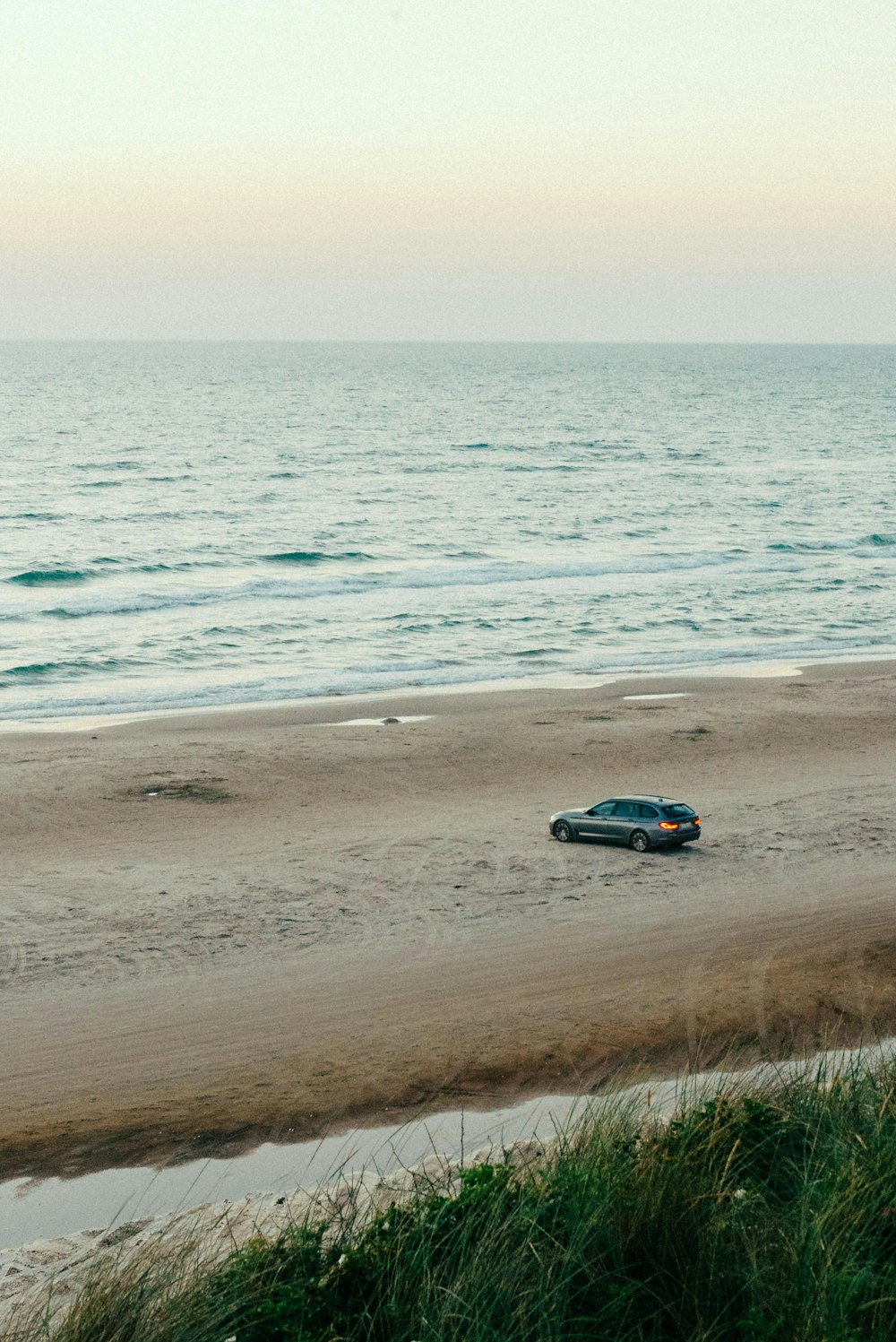 une voiture roulant sur une plage