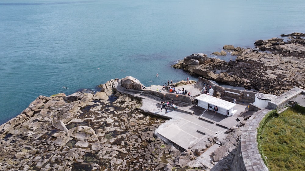 a building on a rocky cliff by the water