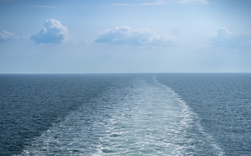 a body of water with a blue sky and clouds