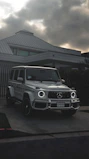Elegant white luxury SUV parked in front of a modern mansion
