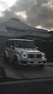 Elegant white luxury SUV parked in front of a modern mansion