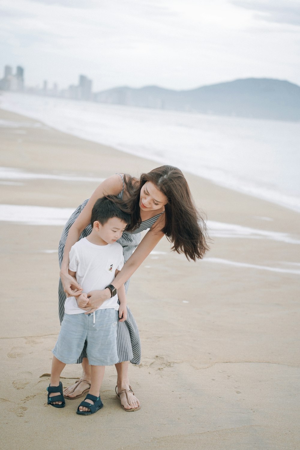 a person holding a child on a beach