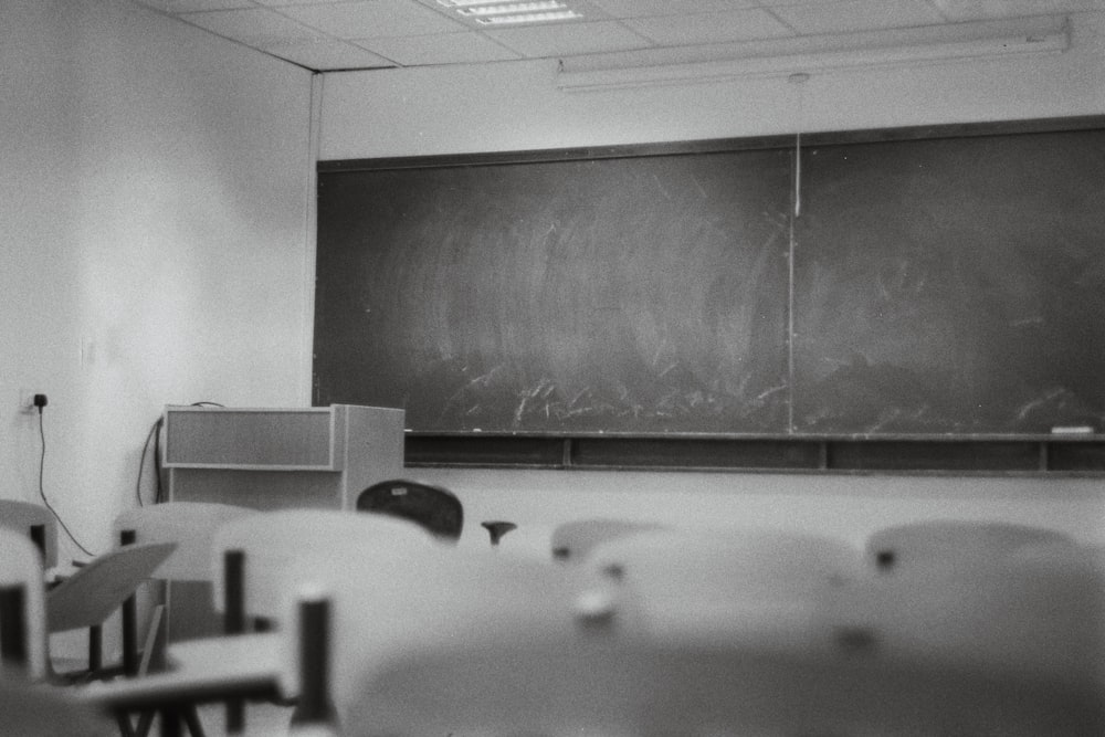 a black and white photo of a classroom with a chalkboard