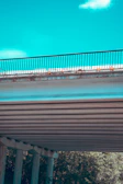 Close-up of fresh concrete being poured into a railway bridge mold on a sunny day.