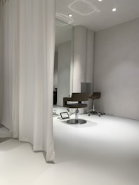 A sleek full-length wall mirror with a minimalist frame reflecting a bright room.