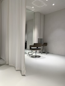 A sleek full-length wall mirror with a minimalist frame reflecting a bright room.