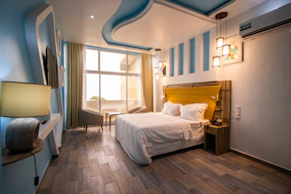 Modern bedroom featuring blue and yellow tones with a view of the Andes.