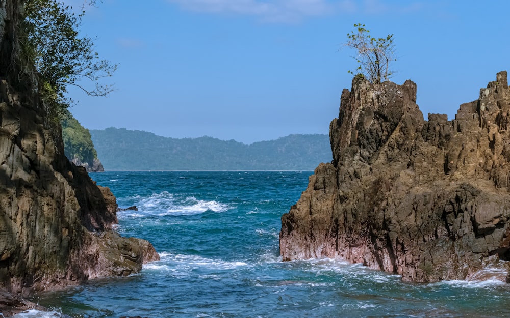 a rocky cliff next to a body of water