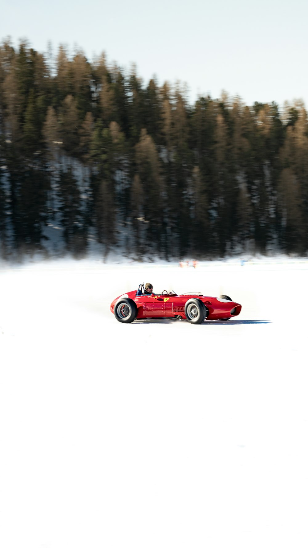 a red car driving on a snowy road