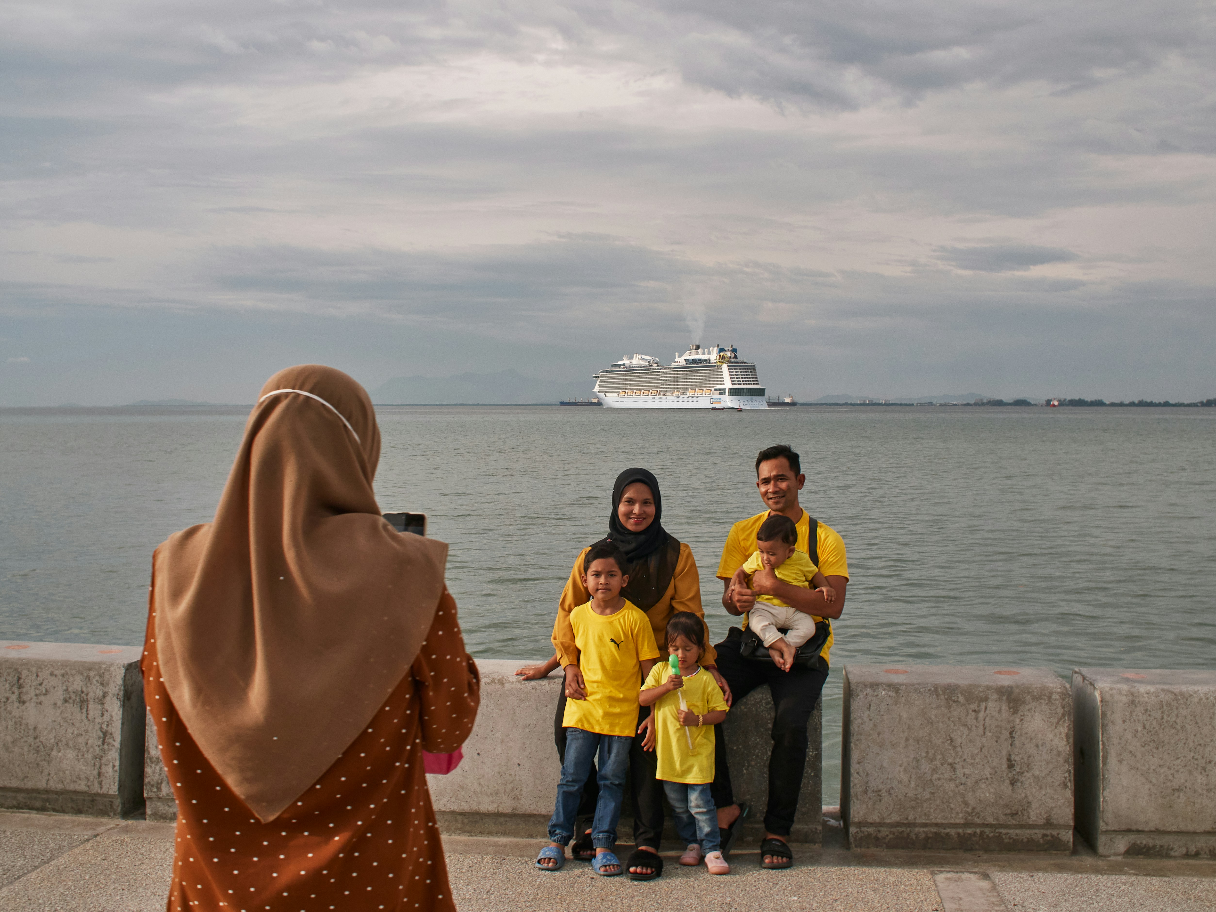 a group of people posing for a photo in front of a large ship