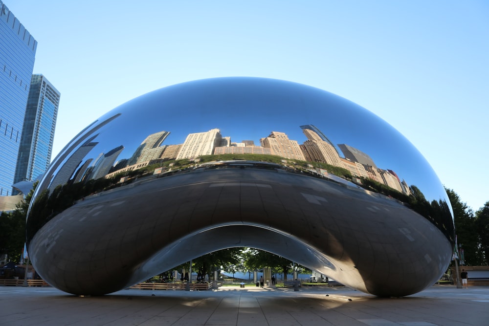 a large reflective sphere with Millennium Park in the background