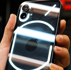 a hand holding a silver and black cell phone