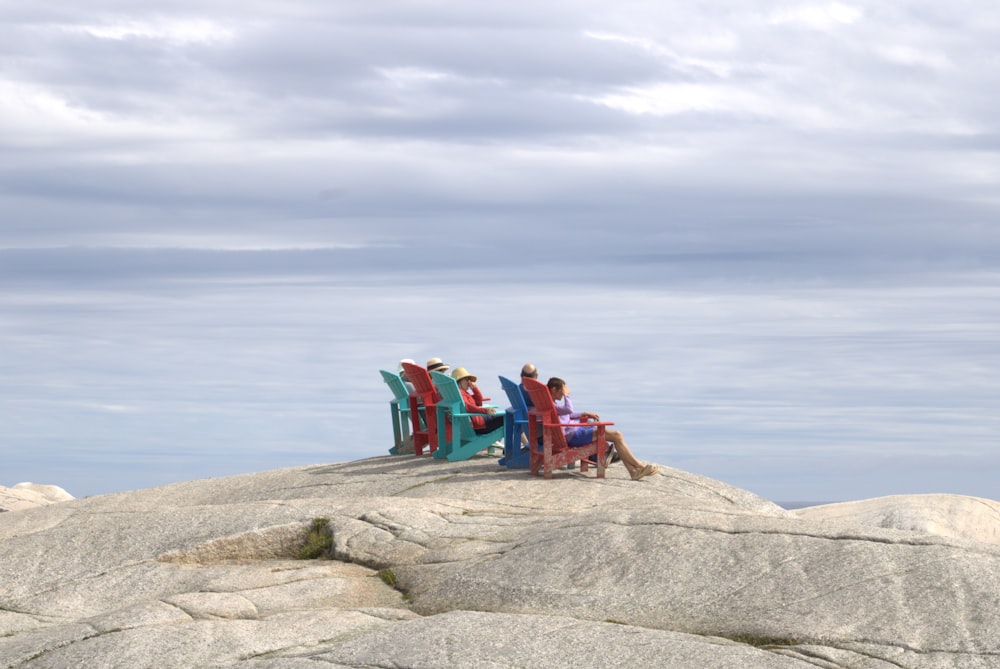 um grupo de pessoas sentadas em um banco em uma praia rochosa