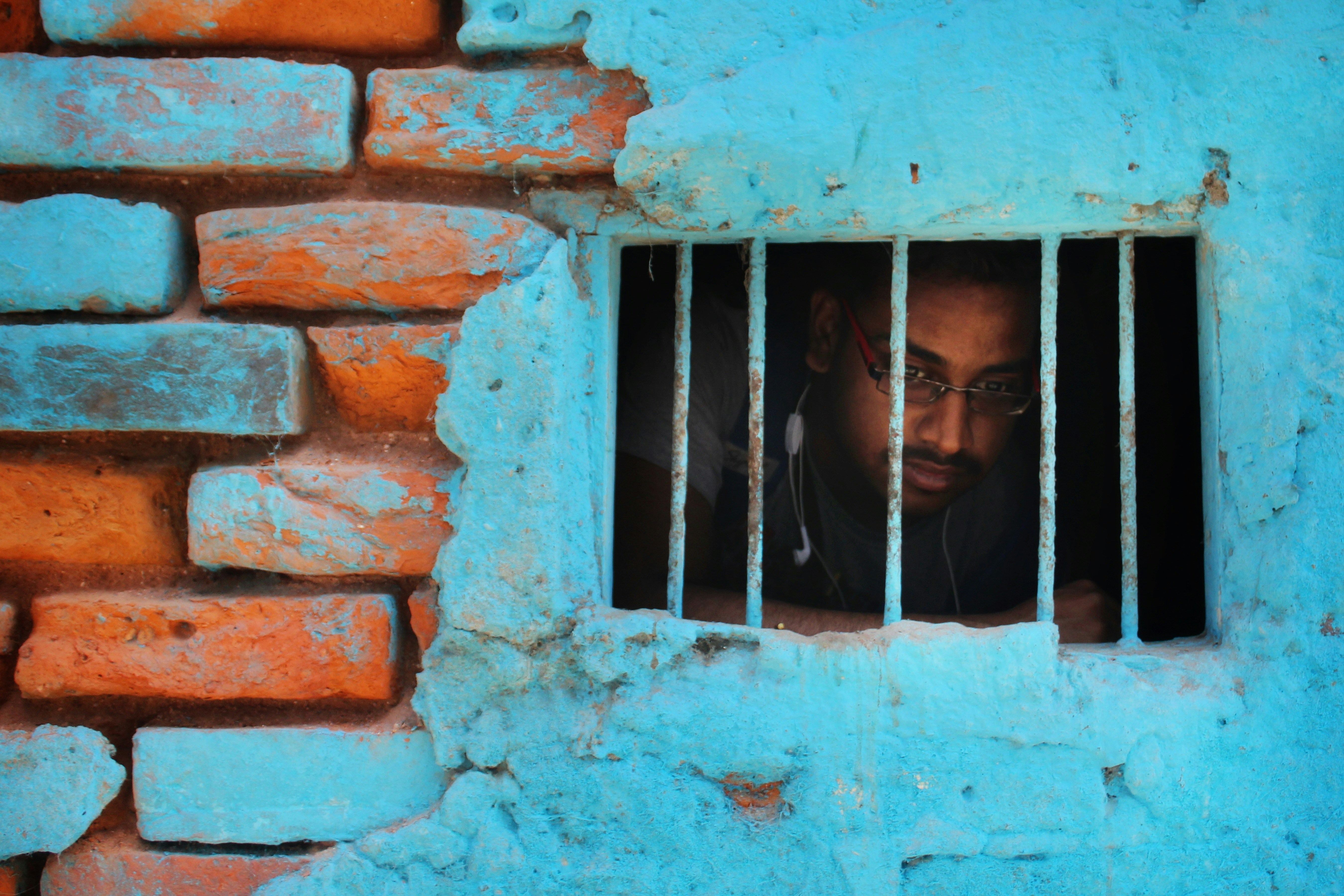a person looking out a window (Photo by Dibakar Roy on Unsplash)