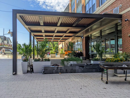 A modern office patio decorated with large planters filled with colorful flowering plants and greenery.