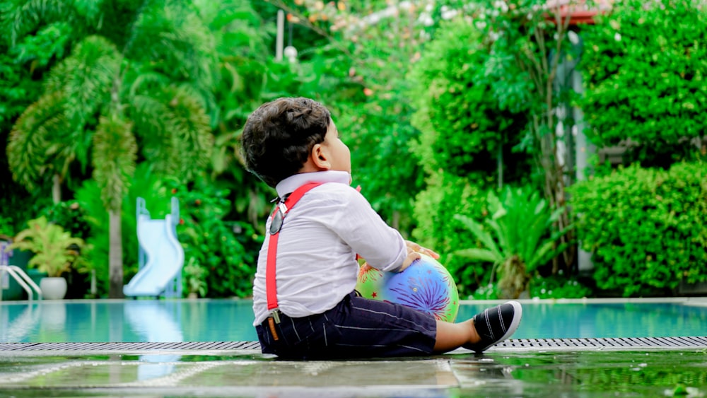 a boy sitting in a pool