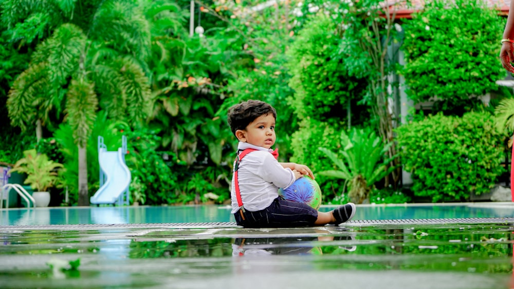 a boy sitting in a pool