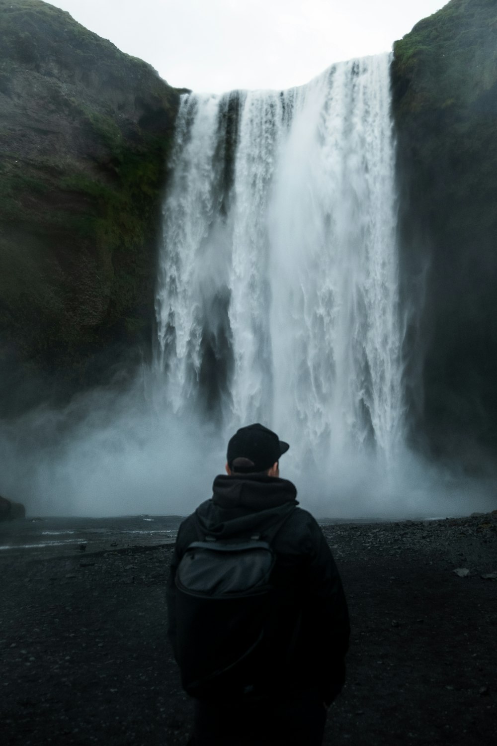 a person standing in front of a waterfall