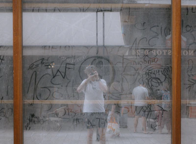 a group of people standing in front of a wall with graffiti