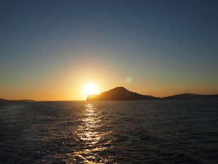 a body of water with a mountain in the distance