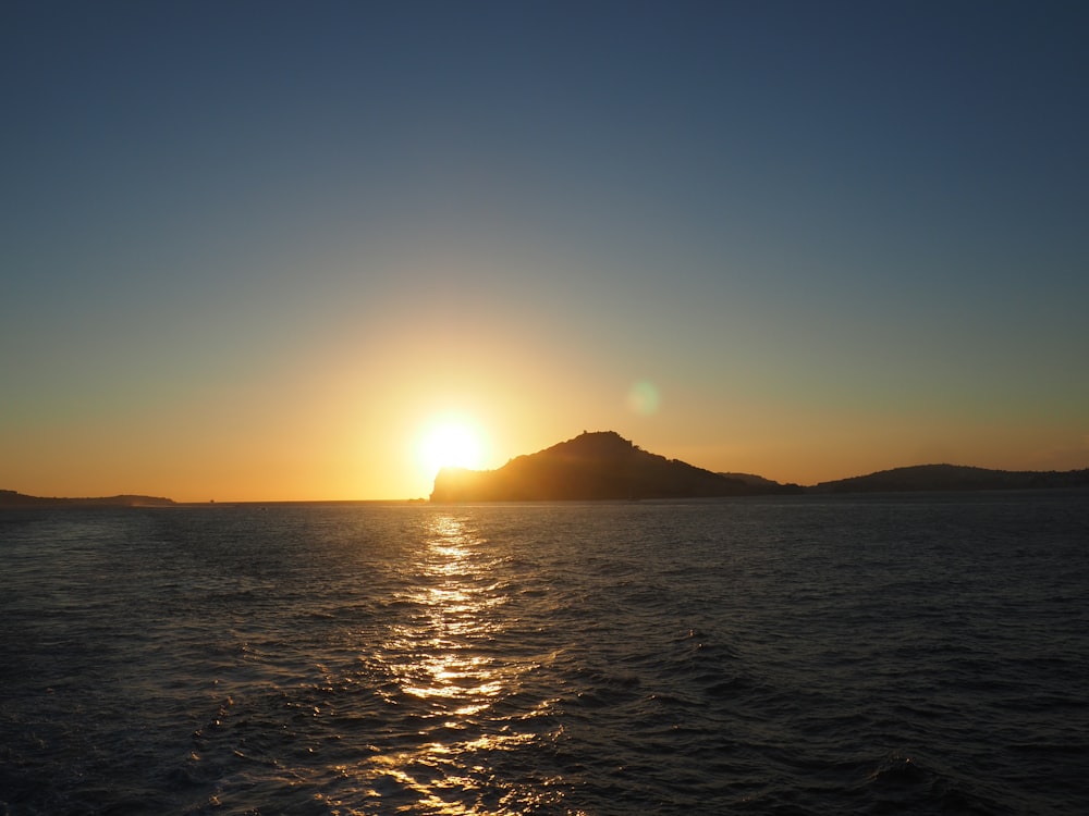 a body of water with a mountain in the distance