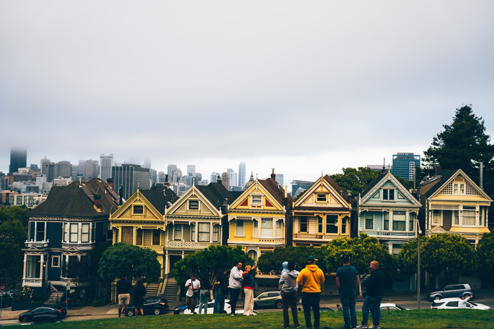 a group of people standing in front of a row of houses