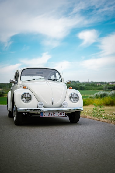 A well-maintained classic car parked on a charming UK village street under soft daylight.