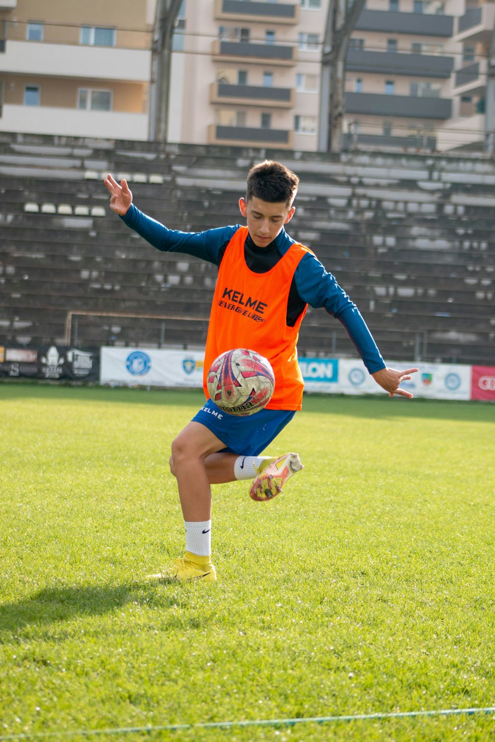 a boy in an orange shirt running on a field