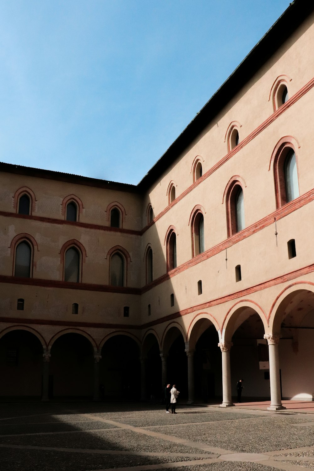 a large building with a large arched entrance with Collegium Maius in the background