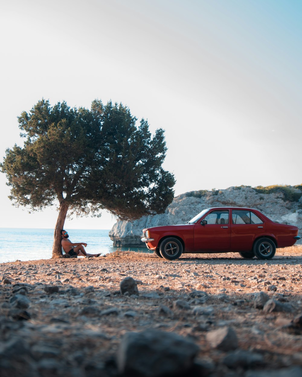 a red car parked on a beach