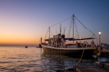 A center console boat docked with a soft sunset casting warm hues over the deck.