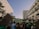 A crowd of people gathered between tall buildings, holding signs with slogans such as 'Abort Alito' and 'Overturn Roe? Hell No!' in a protest. The scene captures a mixture of emotions as people advocate and express their views.