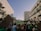 A crowd of people gathered between tall buildings, holding signs with slogans such as 'Abort Alito' and 'Overturn Roe? Hell No!' in a protest. The scene captures a mixture of emotions as people advocate and express their views.
