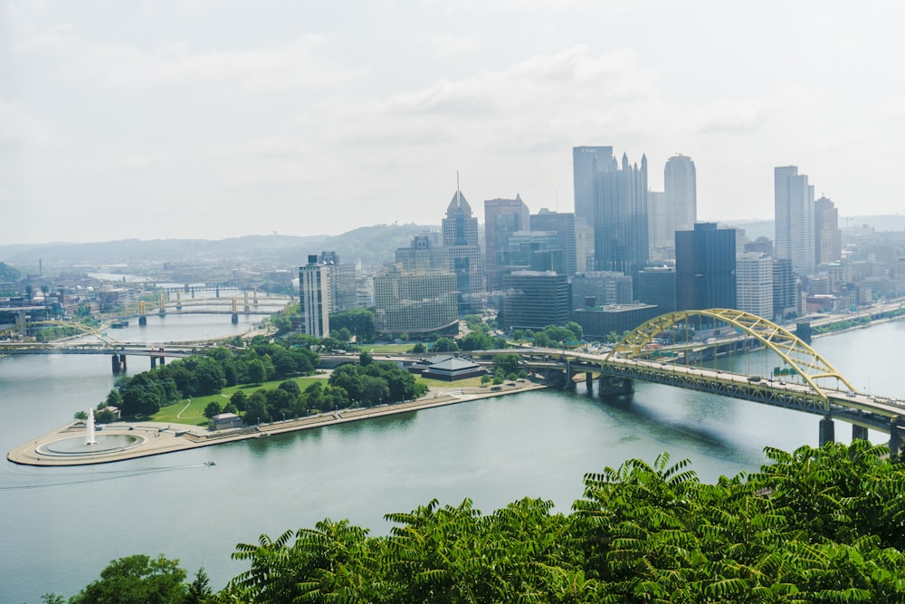 a bridge over a river with a city in the background