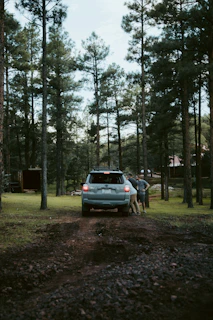 A family loading luggage into a silver sedan ready for a long-distance journey.